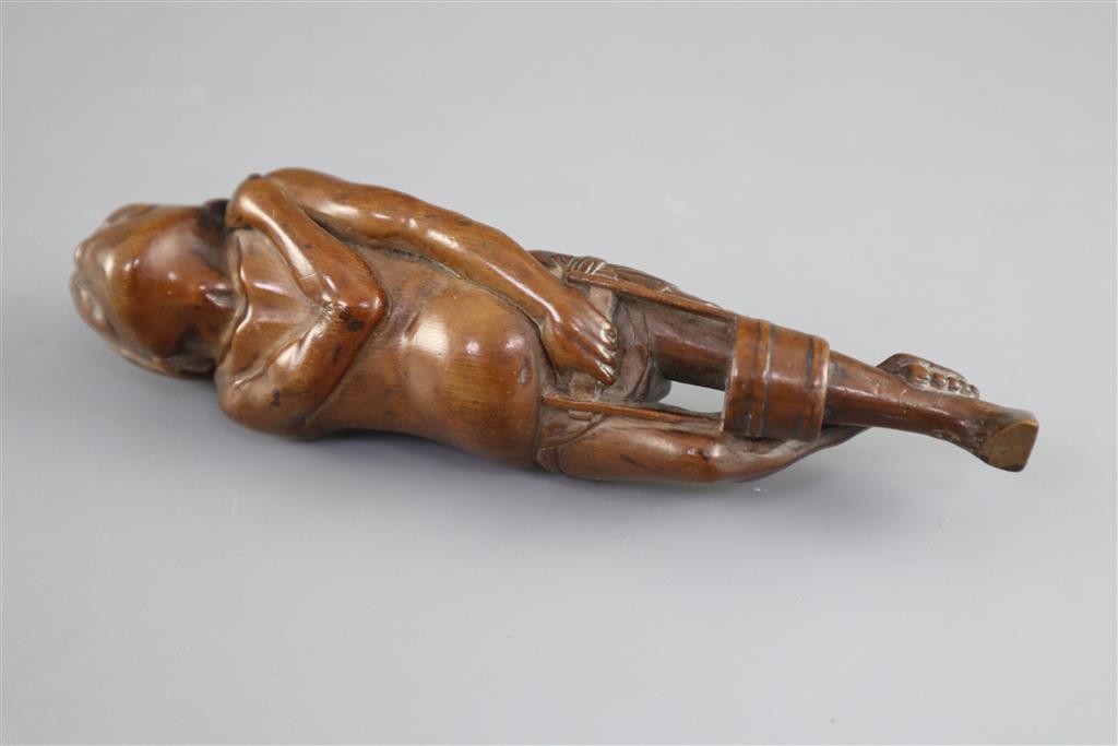 A Japanese cherrywood okimono netsuke of a farmer, early 19th century, 15cm long